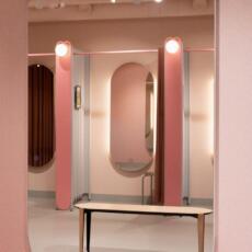 Dubbele boogspiegel, hangend aan de muur in een pashokje